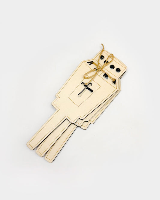 Lesene sveče na kupu, zvezane z darilnim trakom.