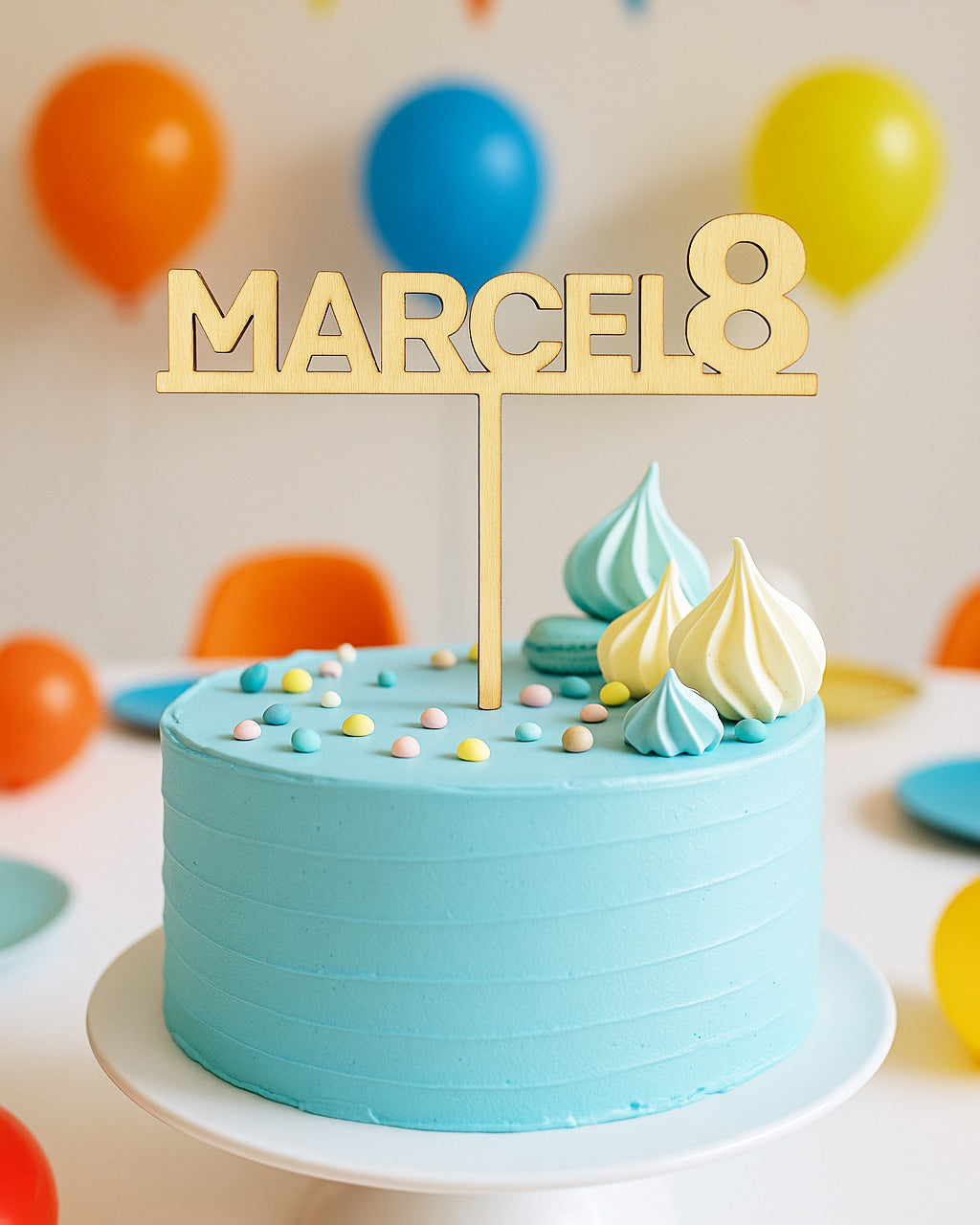 Na sliki je turkizna torta s topperjem oz napisom iz lesa. Na palici je ime Marcel in številka 8