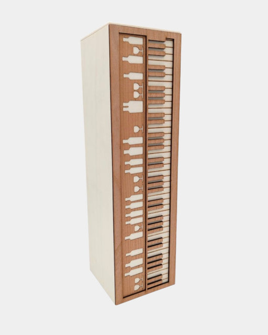 vinska škatla iz lesa topol, z motivom klavirja. Na eni strani so iz furnirja izrezane tipke, na zgornji strani pa so izrezani kozarci in steklenice.