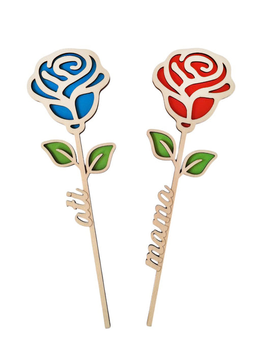 Dve leseni vrtnici iz topola. Obojestranski. Na sliki sta na levi strani z modrim cvetom in napisom ati na steblu. Na desni strani je rdeča vrtnica z napisom na steblu mama.