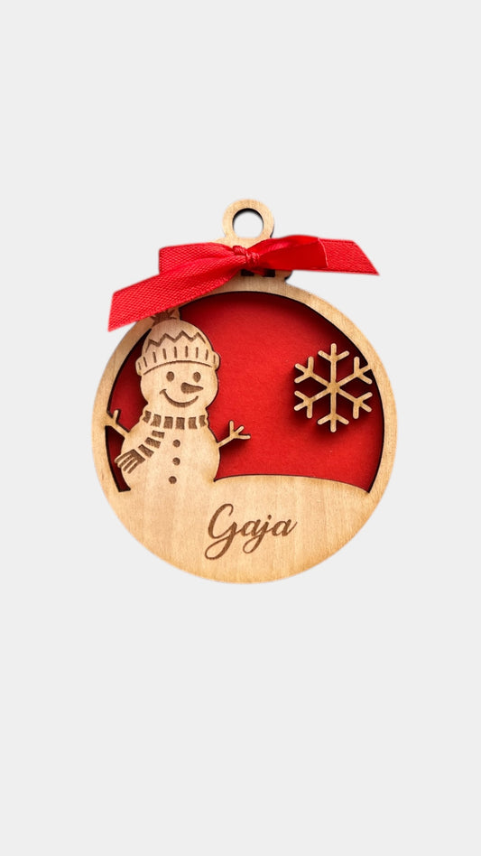 Leseni okrasek, lesena božična krogilica, z rdečo pentljo, snežinko in snežakom. Personalizirano božično darilo. Lesen okasek za smreko. 